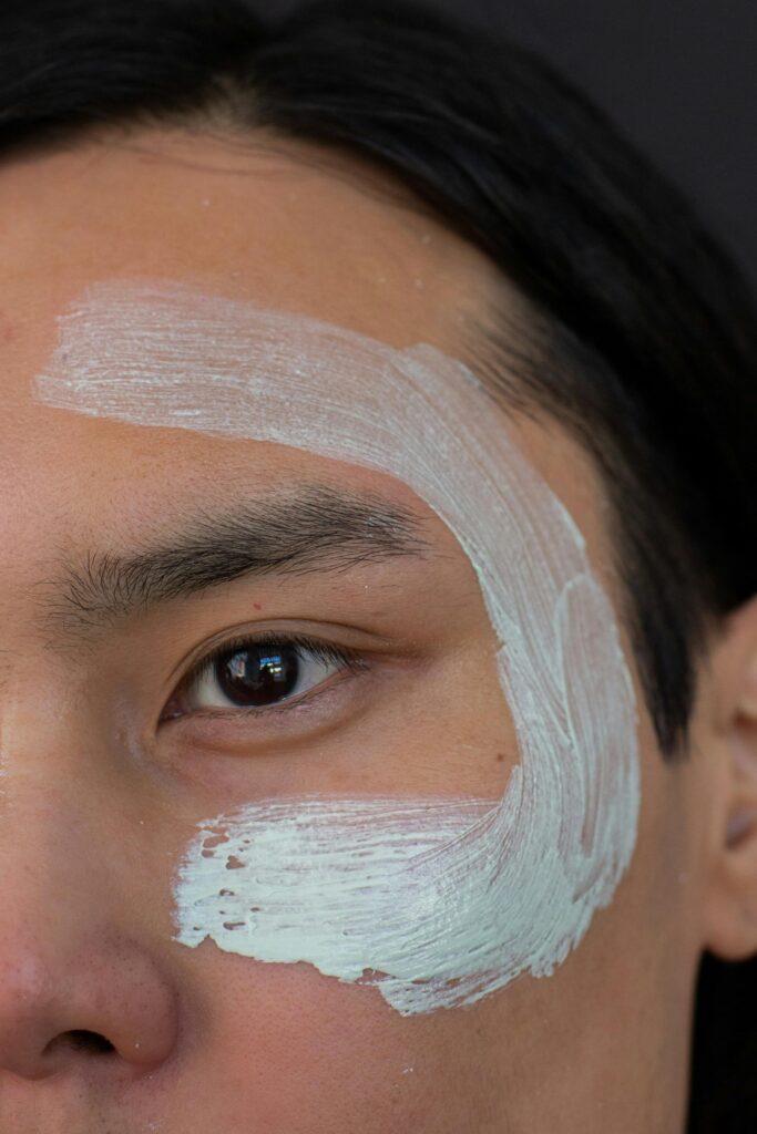 Close-up of an Asian man's face with skincare mask, promoting wellness and rejuvenation.