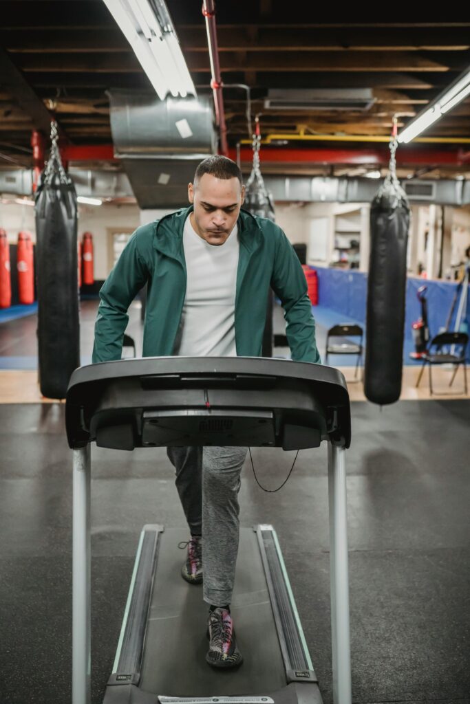 A determined man working out on a treadmill in a well-equipped gym, enhancing fitness and endurance.